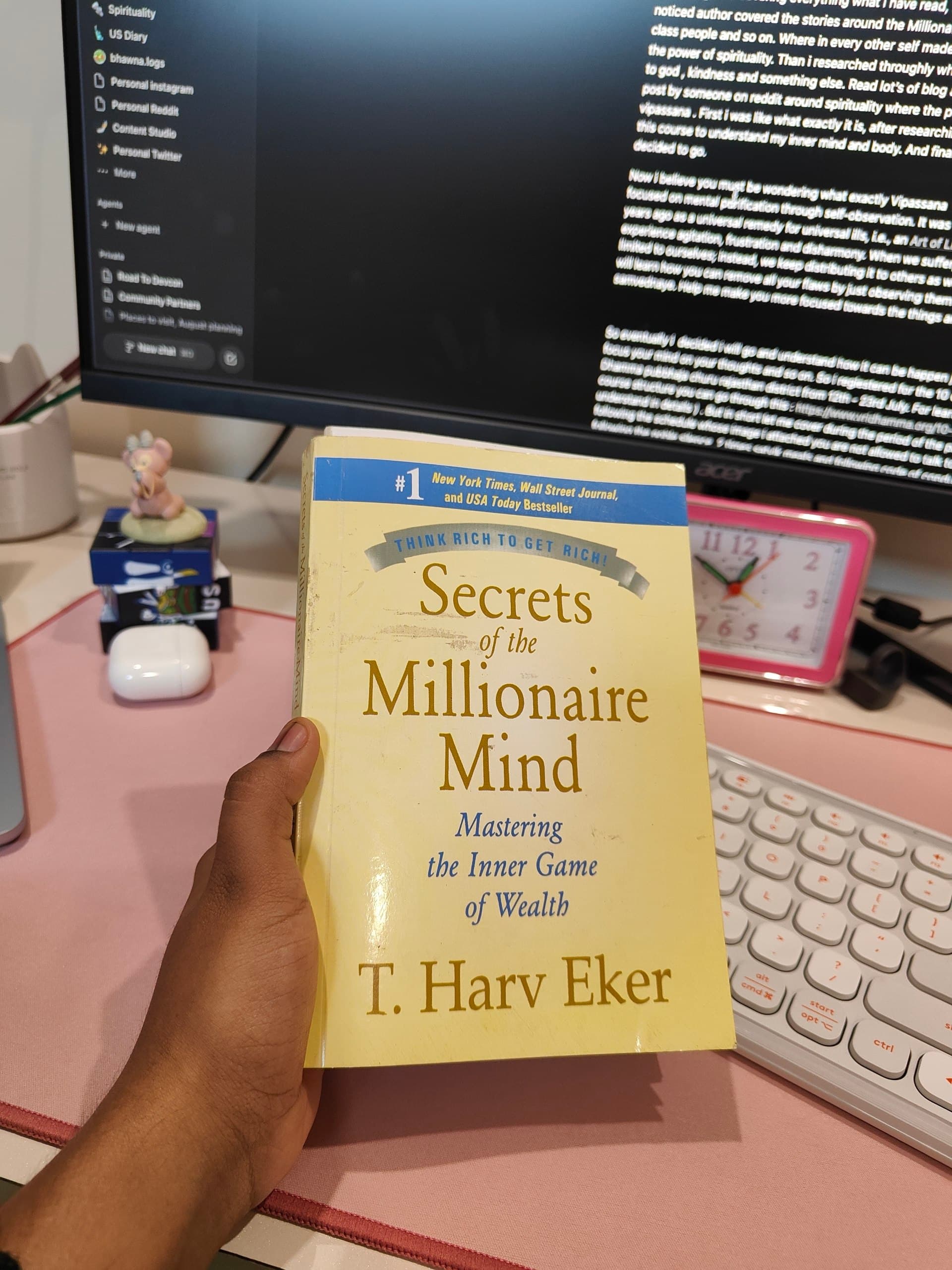Bhawna holding the book Secrets of the Millionaire Mind at her desk
