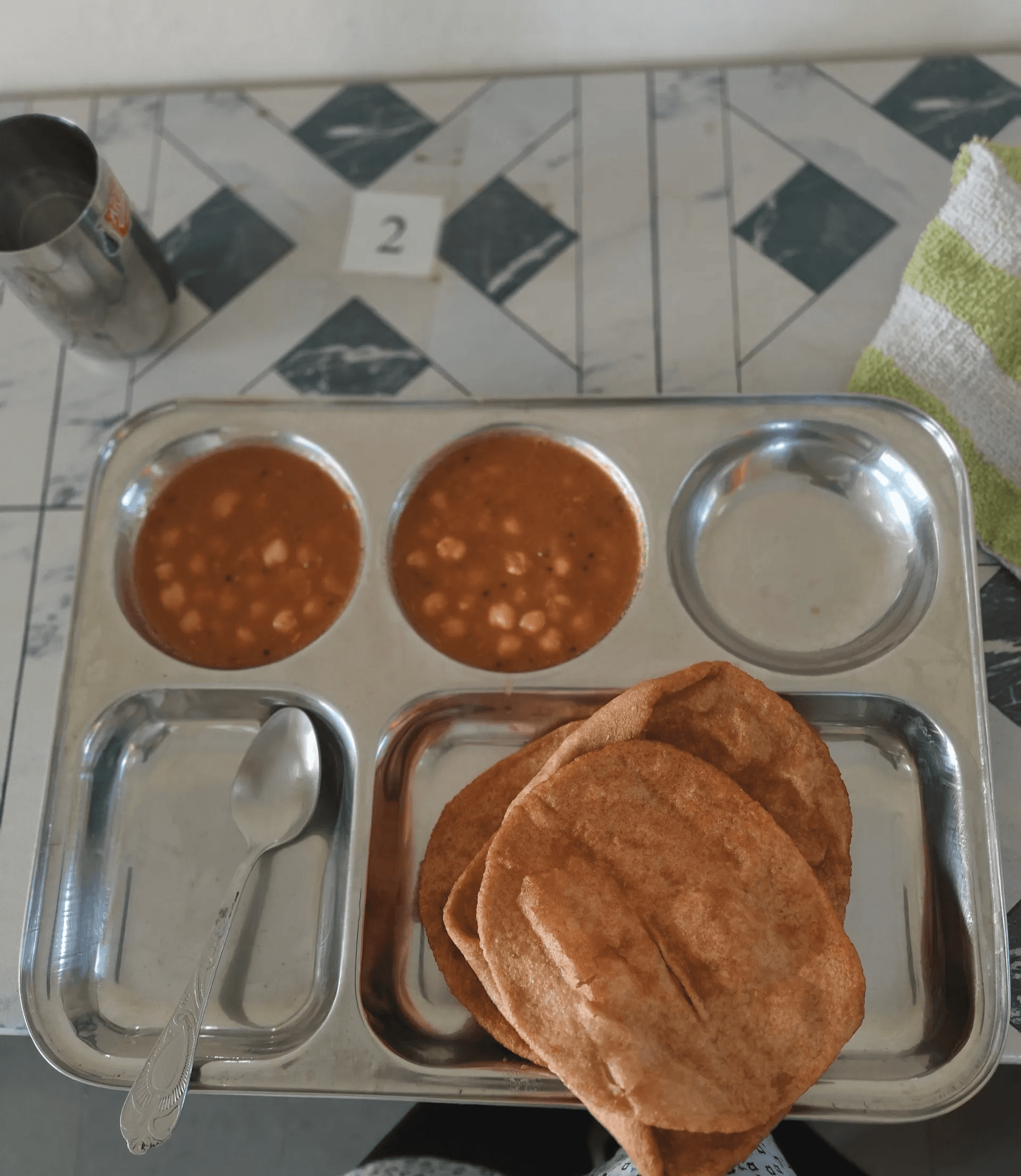 A breakfast tray with puri and chickpea curry